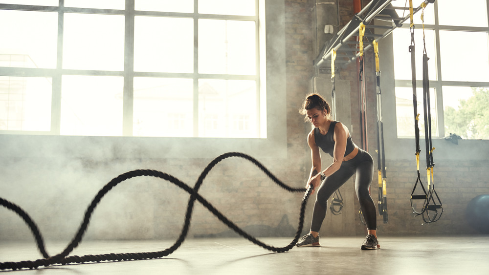 woman using battle ropes