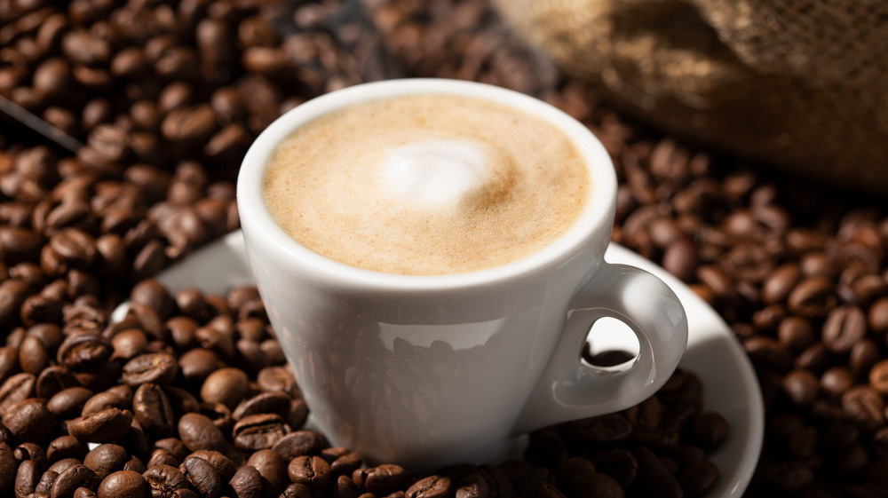 Cappuccino on a bed of coffee beans