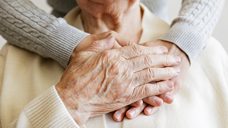 young woman with arms around old woman