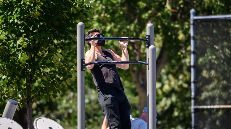 Man doing pull-ups in a park