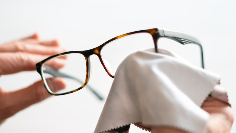 Close up of hands holding glasses and wiping with a cloth