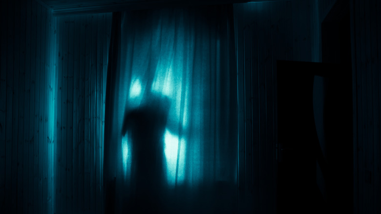 figure behind curtain