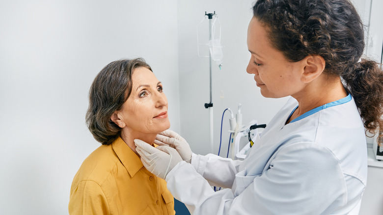 a doctor checks for thyroid swelling