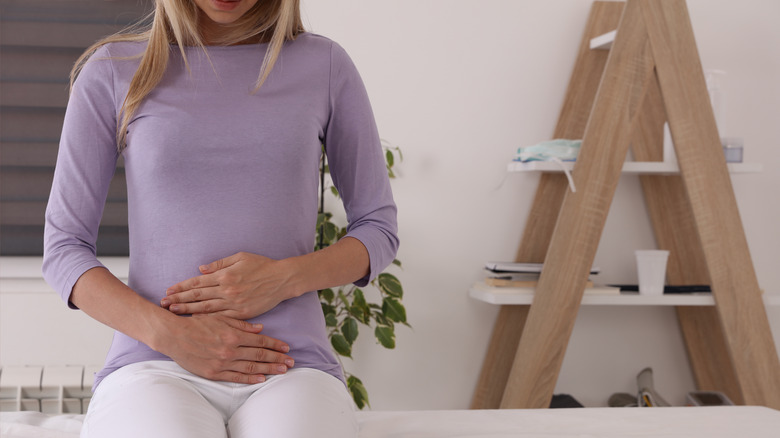 Woman holding lower abdomen