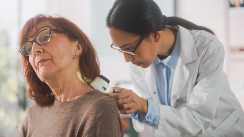 Dermatologist examining woman's skin