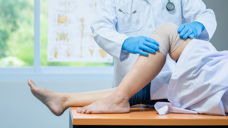 Doctor examining knee injury