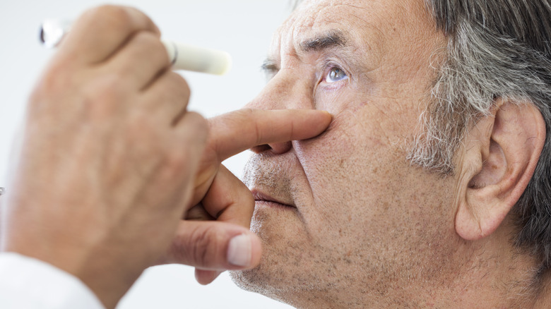 Doctor examining male patient's eye