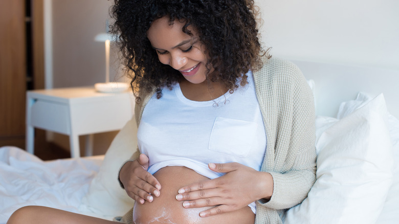 Pregnant woman applying moisturizer