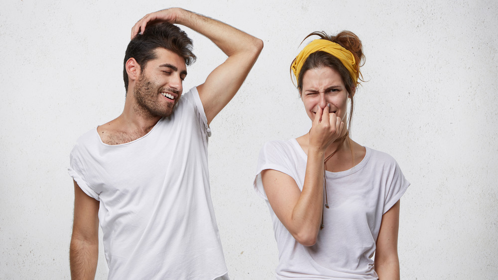 Woman holding her nose to her partner's odor 