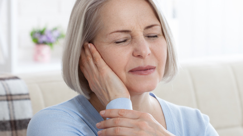 Ailing elderly female experiencing ear pain