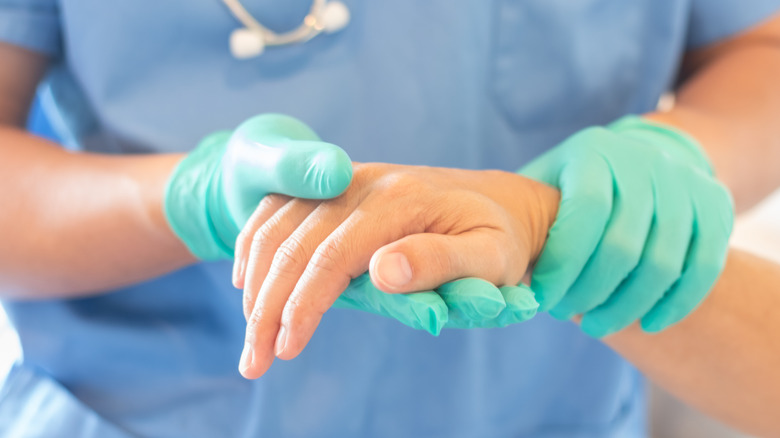 Medical professional examining hand