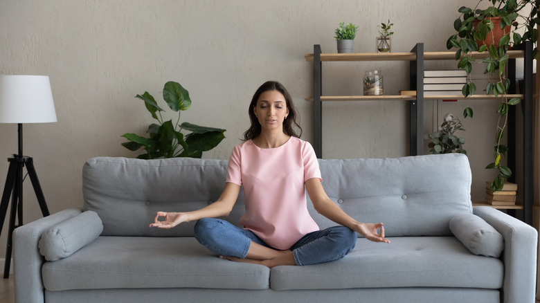 woman in yoga pose on couch