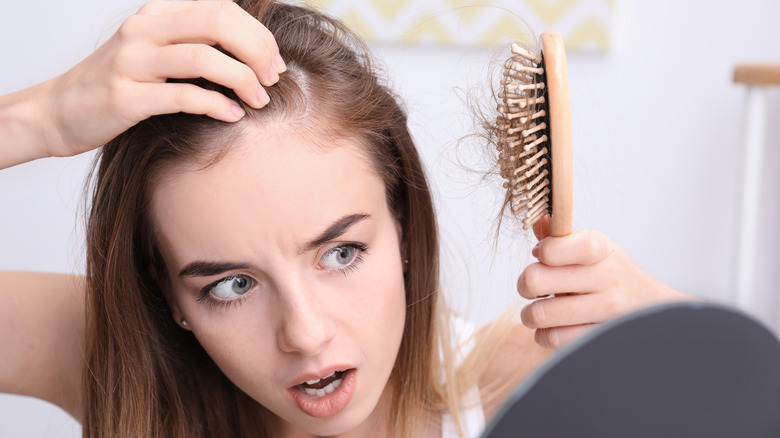 woman with hairbrush full of hair