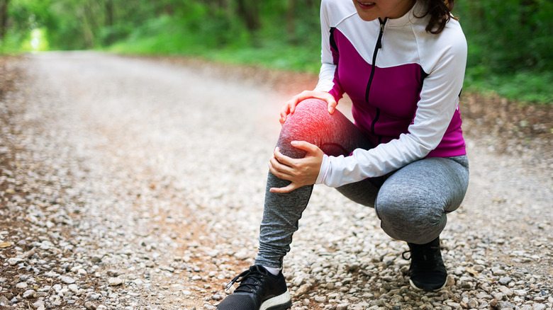 Woman having knee pain while running