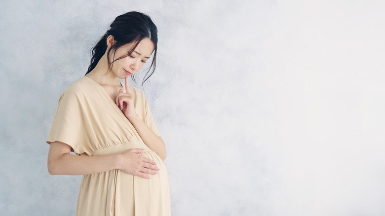 Asian pregnant woman holding belly