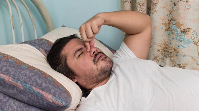 A man in bed with sinus issues
