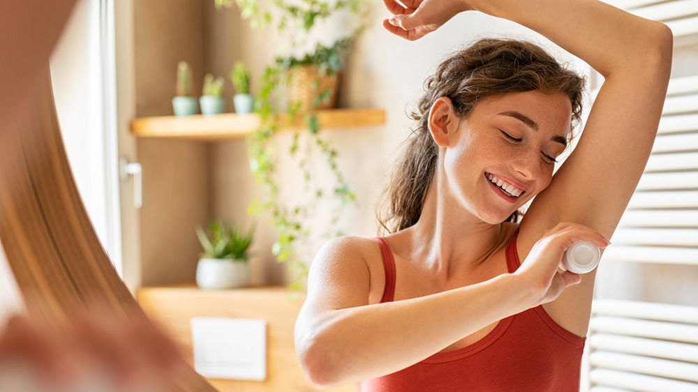 Woman applying antiperspirant 