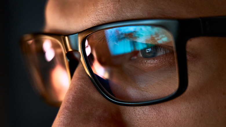 closeup of man in glasses staring at computer