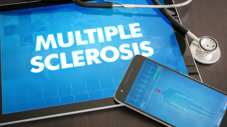 A phone with a display of the human body over a tablet displaying the words "multiple sclerosis"