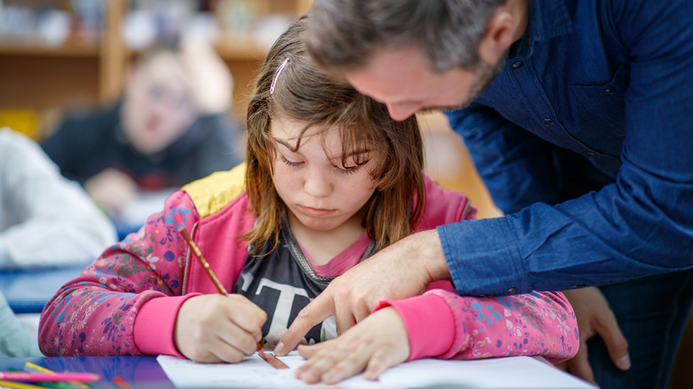 teacher assisting student with schoolwork