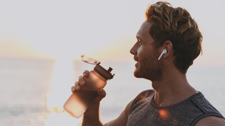 Male runner drinking water 