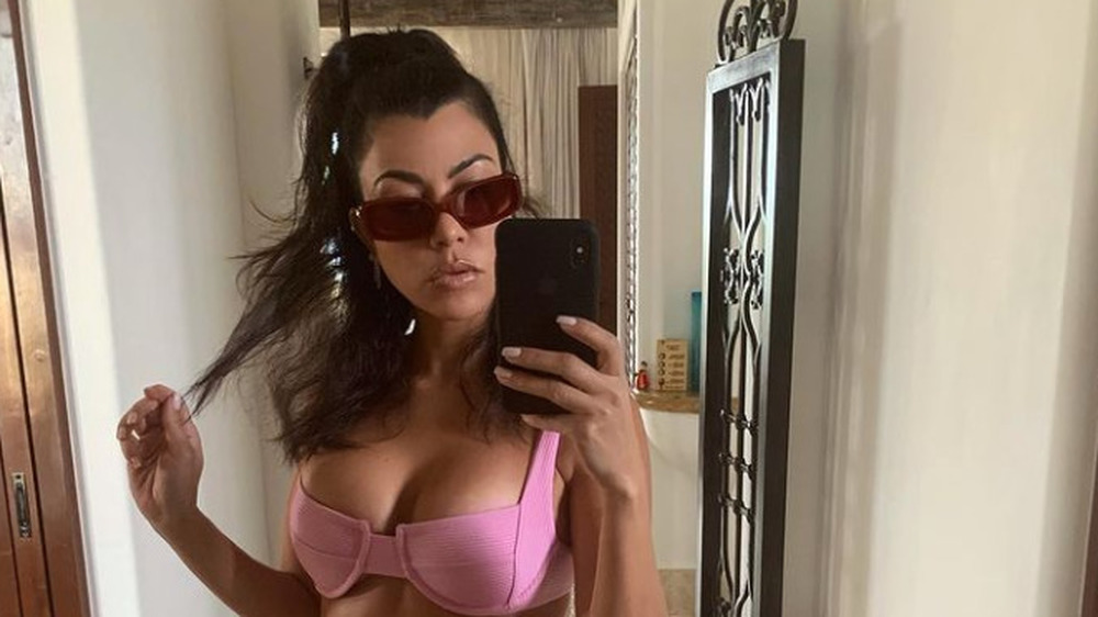 Kourtney Kardashian posing in pink bikini and sunglasses 