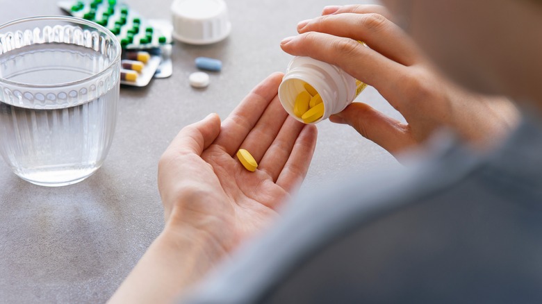 Person pouring pill from bottle into hand