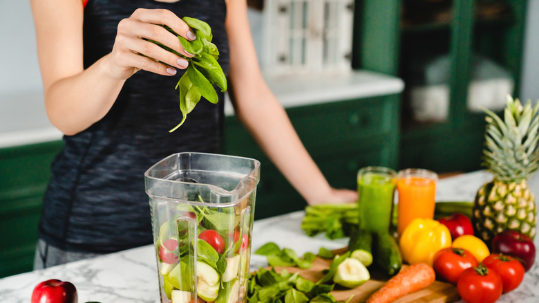 woman making a fruit and veggie smoothie