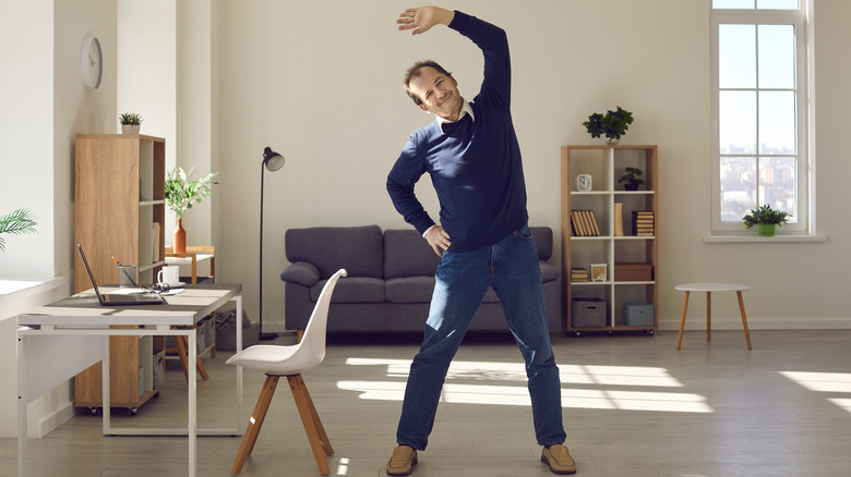 Man stretching next to work desk