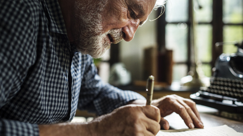 elderly man writing a letter