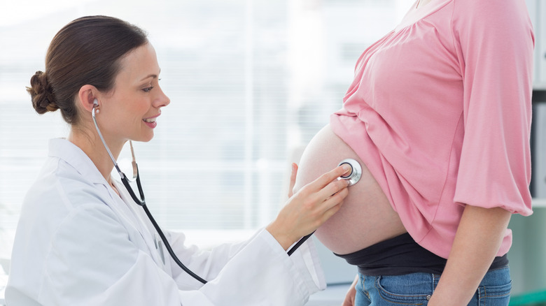 doctor looking at pregnant belly 