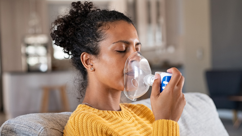 woman using inhaler for her medication