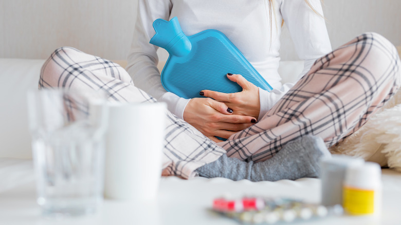 a woman holding hot water bottle