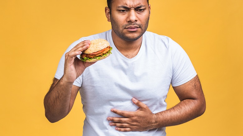 hungry man holding burger