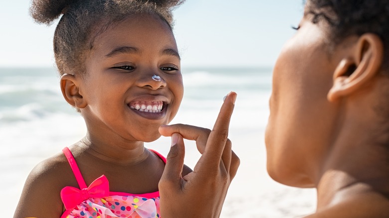 mom applying sunscreen to child