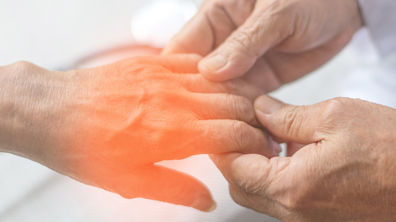 Doctor holding patient's numb hand