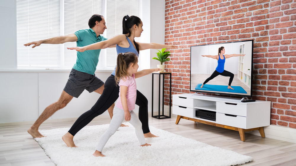 Family doing yoga with video