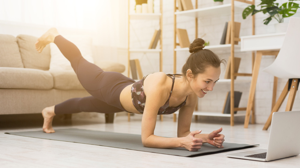 Woman watching laptop, doing yoga