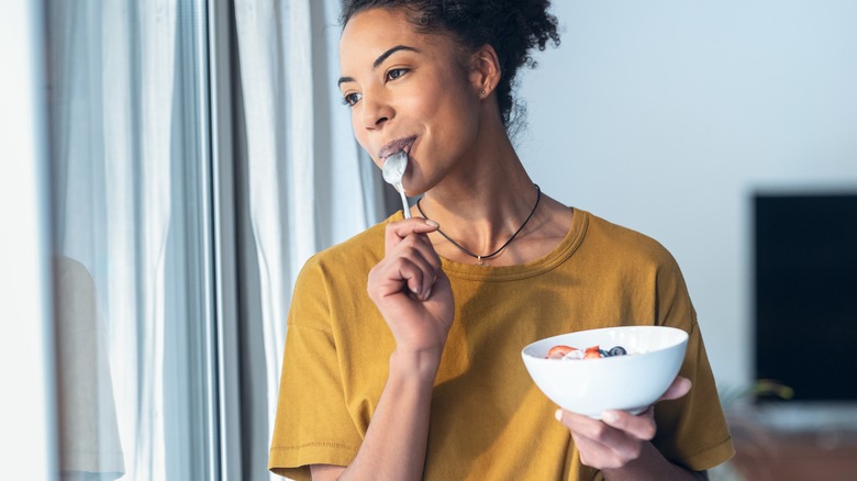 woman eating yogurt bowl