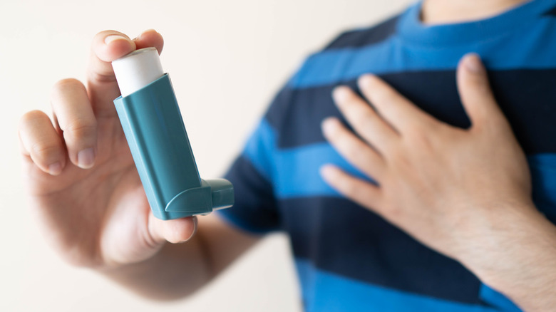 person holding asthma inhaler