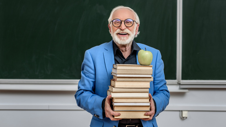 professor holding books, apple