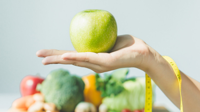 hand holding green apple