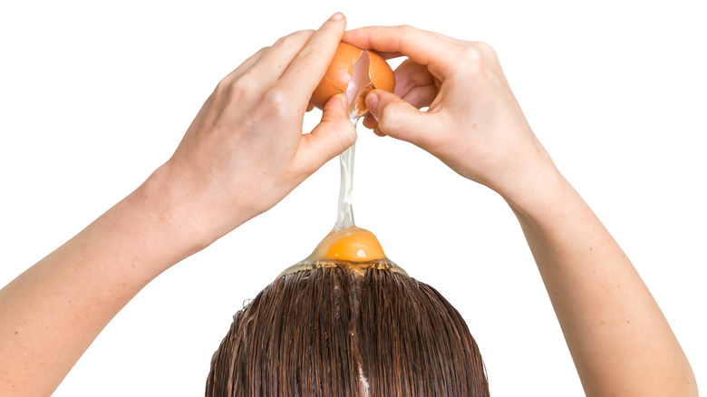 woman applying egg conditioner on hair 
