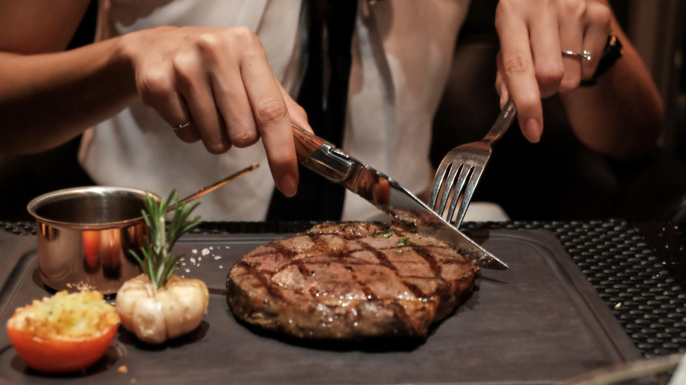 woman cutting steak