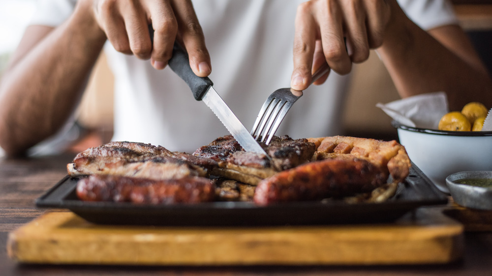 man cutting steak, red meat