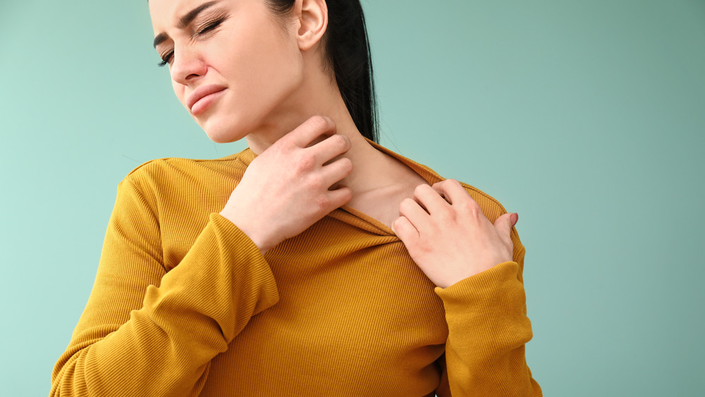 woman scratching neck from allergies