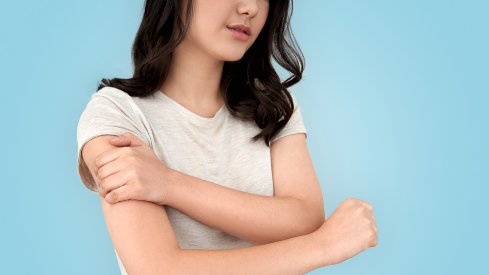 woman clutching arm after injection