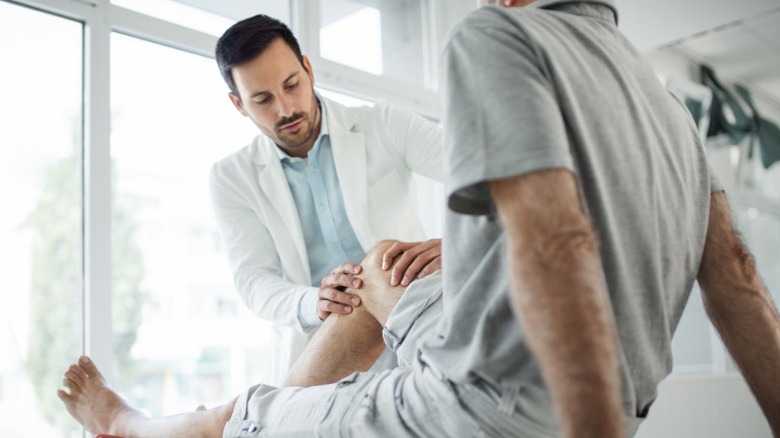 doctor examines patient's knee