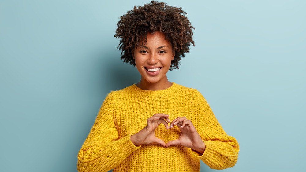 smiling woman touching heart area