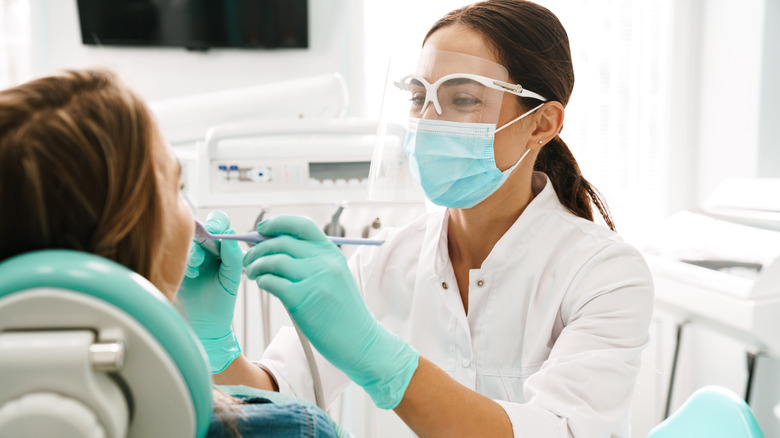 A dentist cleans someone's teeth